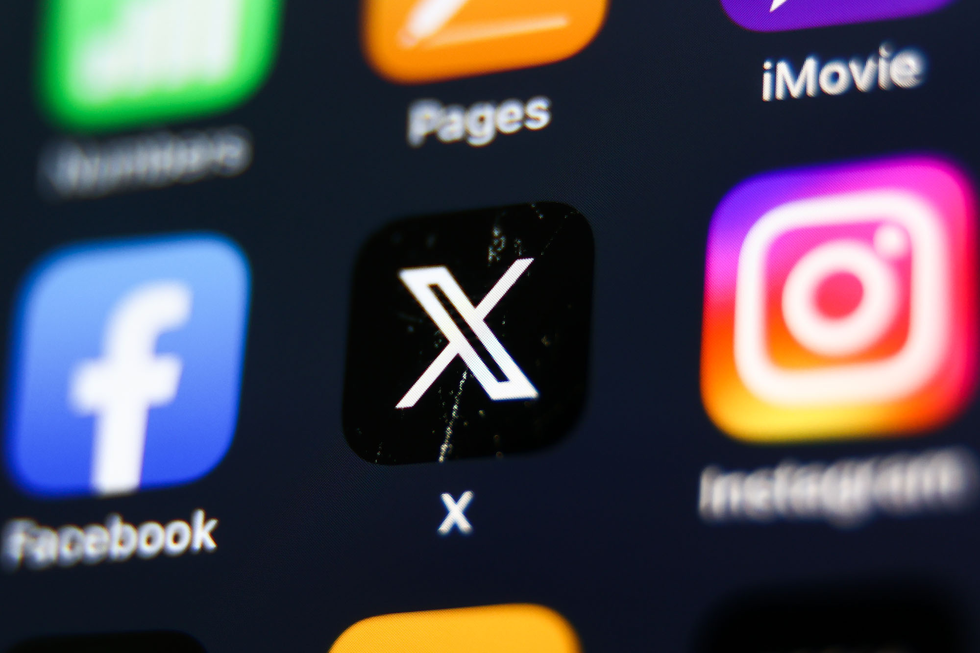 Facebook, X and Instagram icons are seen displayed on a phone screen