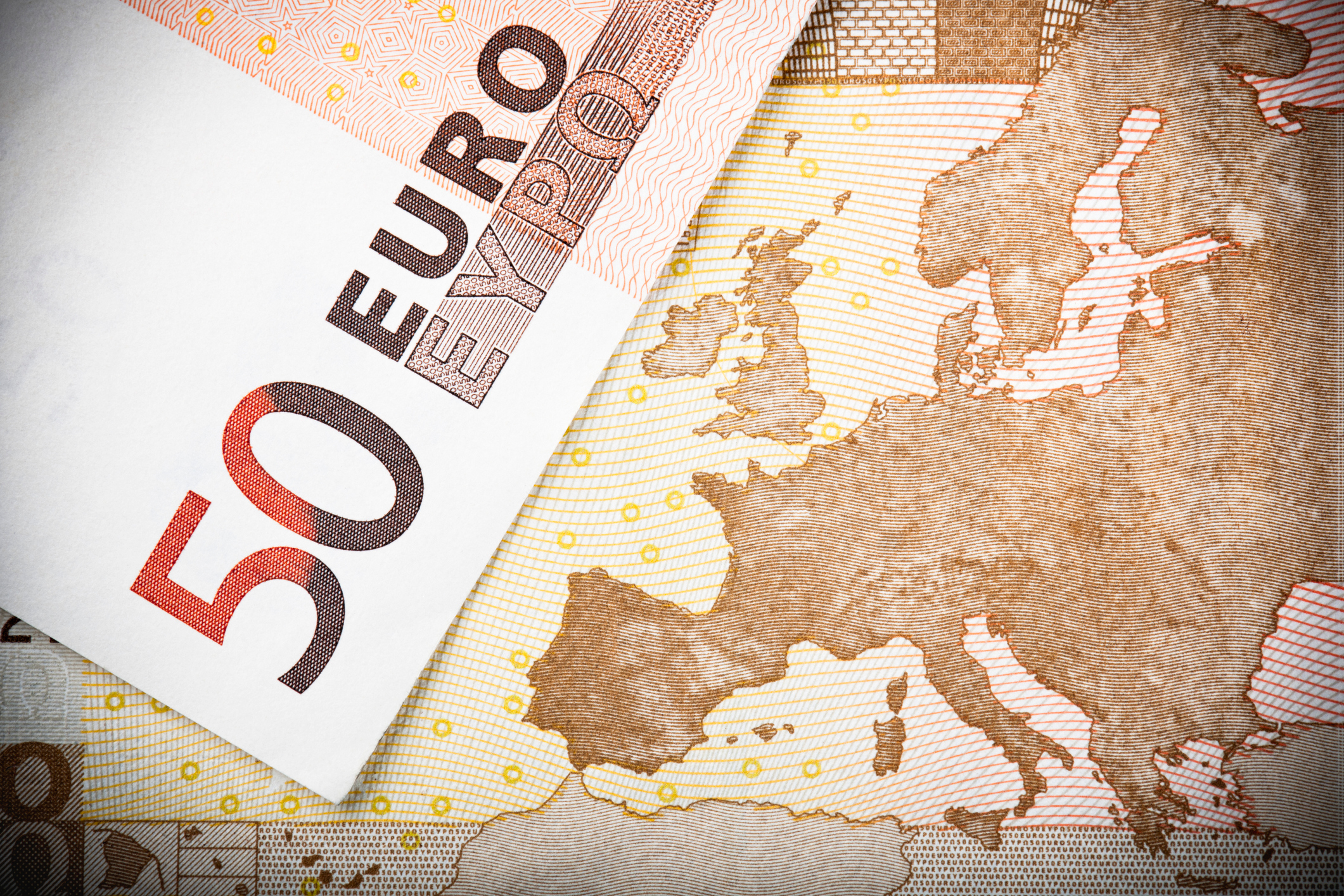 Euro notes close-up: Macro image of two €50 banknotes, with focus on the map of Europe.