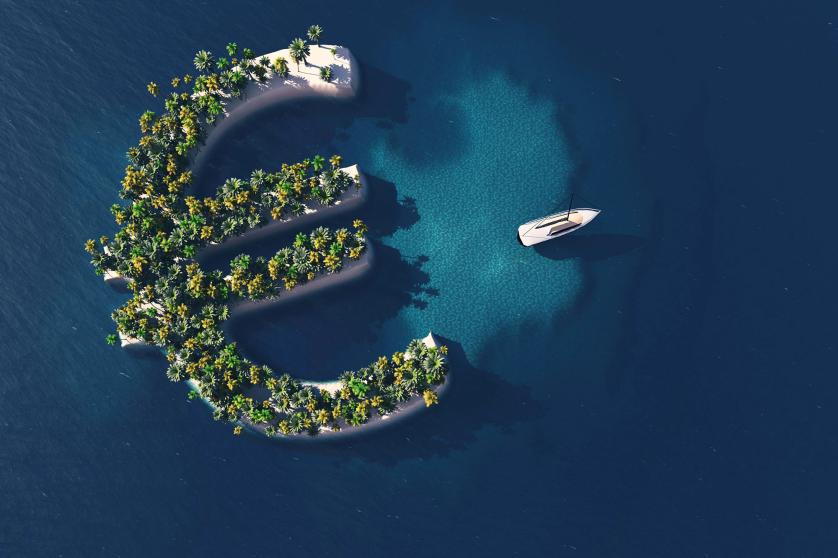 A luxury boat sails away from a green euro symbol-shaped island