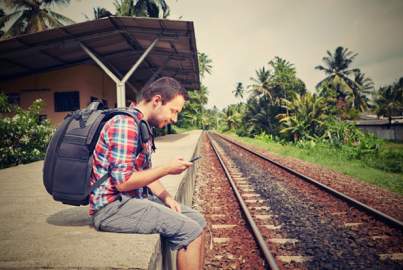 Traveller using his mobile phone while waiting for the train